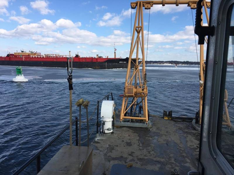 Coast Guard Aids to Navigation Team Bristol watches a tug and barge pass after clearing the deep draft channel of a buoy that was knocked off position Tuesday, Jan. 9, 2018, in the Providence River. The buoy was knocked off station by ice photo copyright U.S. Coast Guar taken at  and featuring the Power boat class