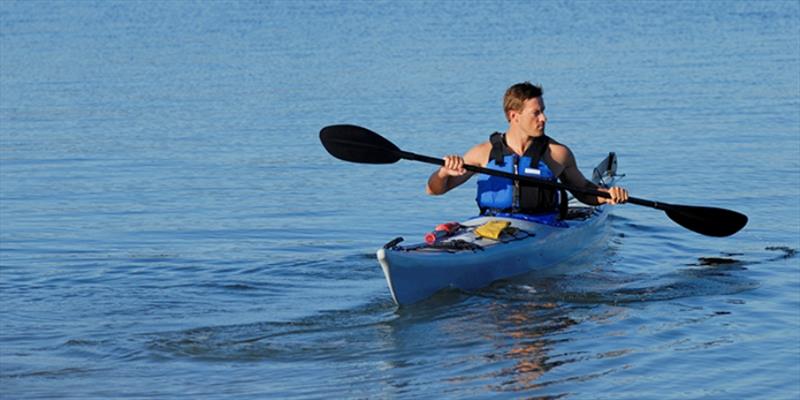 Kayaker wearing a life jacket while paddling - photo © iStock
