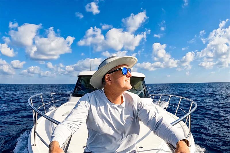 At one with the sea - Lance aboard Caroline 2.0 as they leave Grand Cayman Island in the Caribbean photo copyright Riviera Australia taken at  and featuring the Power boat class